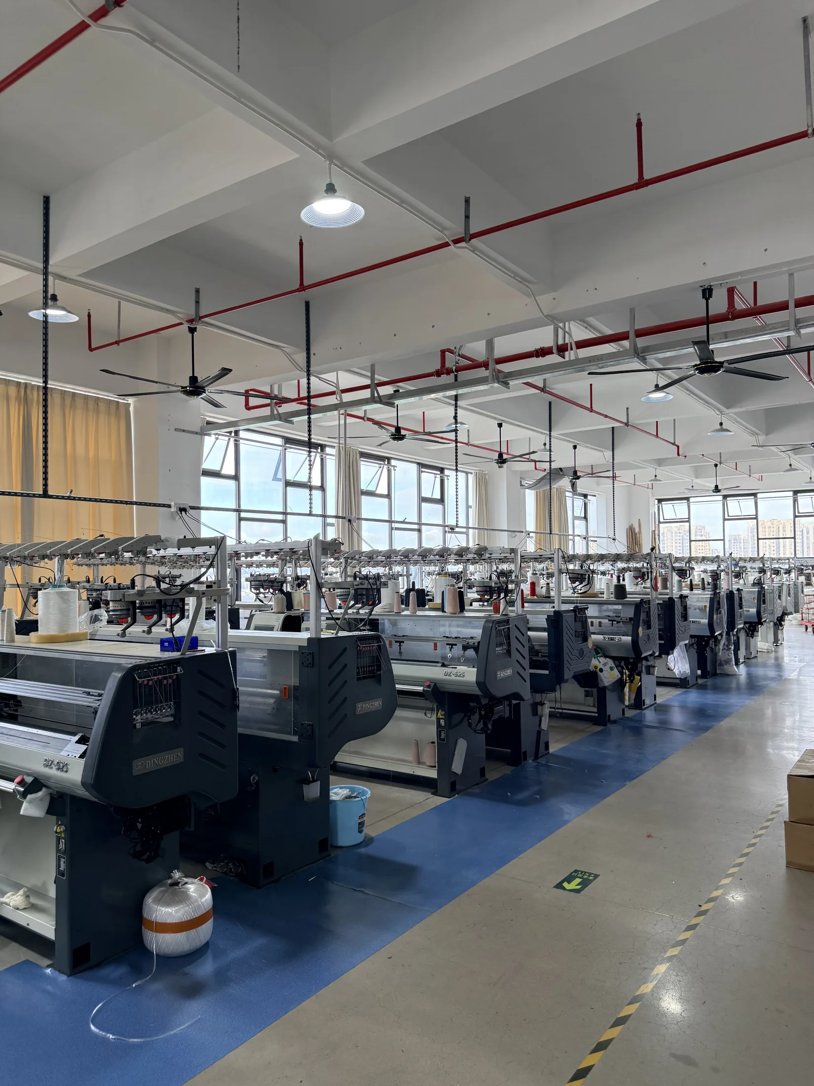 Computerized flat knitting production floor at Rishi Apparel in Dongguan
