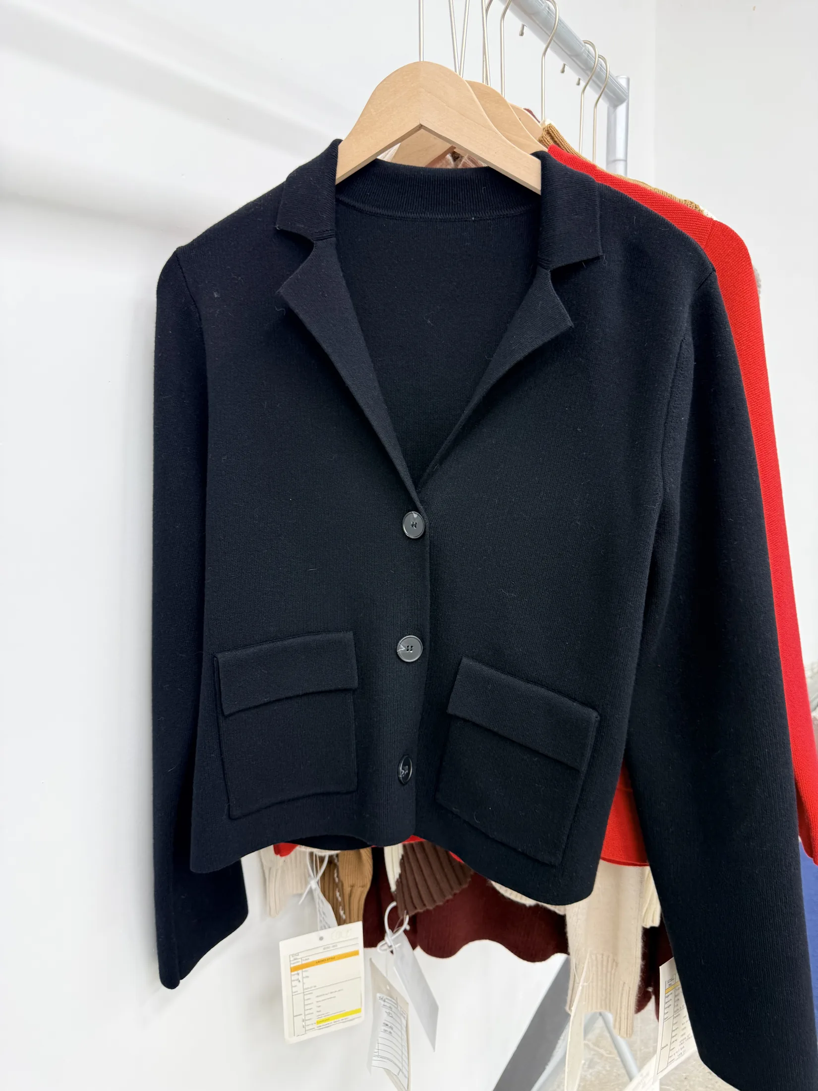 Black knit cardigan shown as a knitwear construction reference