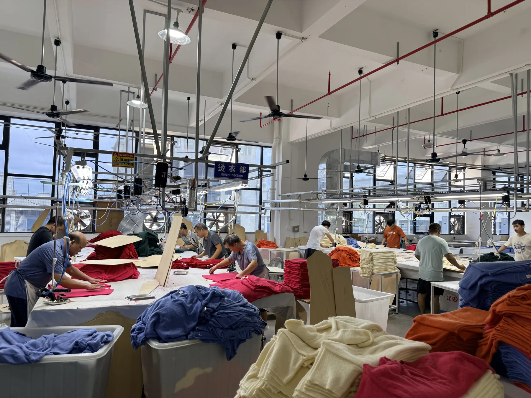 Knitwear finishing workshop handling folded garments before packing
